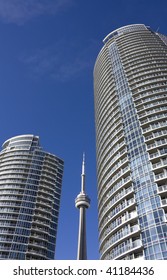 CN Tower beside condominium in toronto against clear blue sky