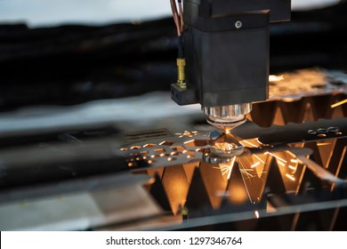 The CNC fiber laser cutting machine cutting the metal plate with the sparking light. The sheet metal working operation.