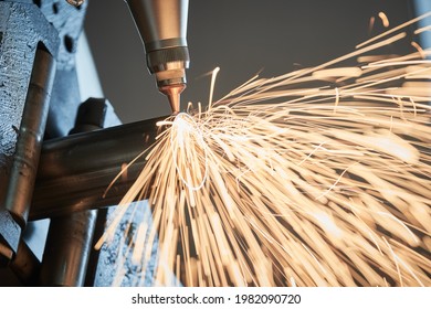 CNC Laser Cutting Of Round Metal Rolling Pipes On Tube Laser Cutting Machine With Sparks