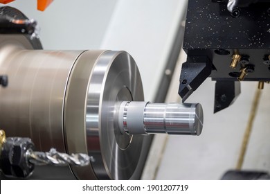 The  CNC lathe machine cutting the metal shaft parts. The hi-technology metal working processing by CNC turning machine .