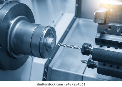 The CNC lathe machine drilling process the metal parts in the light blue scene. The hi-technology metal working processing by CNC turning machine . - Powered by Shutterstock