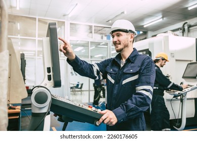 CNC Lathe Machine Engineer Operator Worker Working Entering Work Batch Production Program Data at Heavy Metal Factory  - Powered by Shutterstock