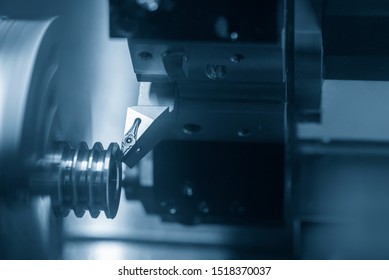 The CNC Lathe Machine In Metal Working Process Cutting The Groove At The Pulley Parts With The Cutting Tools. The Automotive Parts Production Processing By CNC Turning Machine .