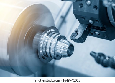 The CNC lathe machine in metal working process finish cutting the metal cone shape parts  with lighting effect. The hi-technology metal working processing by CNC turning machine .