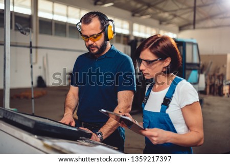 CNC Machine Operator typing fabrication program on the computer in industrial factory
