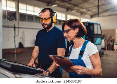 CNC Machine Operators Working In Industrial Factory Hall