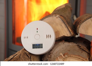 A CO Detector In Front Of A Burning Fireplace