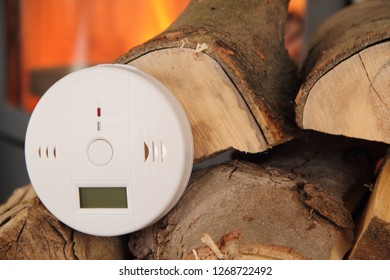 A CO Detector In Front Of A Burning Fireplace