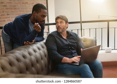 Co workers casually discussing ideas on sofa in modern workplace - Shutterstock ID 1284860587
