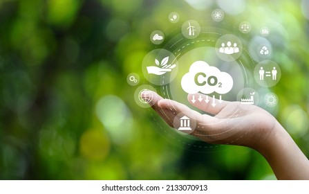 CO2 Emission Reduction Concept In Hand With Environmental Icons, Global Warming, Sustainable Development, Connectivity And Renewable Energy Green Business Background.