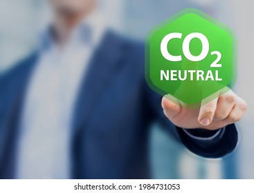 CO2 neutral commitment in business, finance and industry to reduce carbon dioxide emissions and limit global warming and climate change. Concept with person touching button to decarbonize.