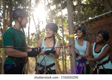 Coach assisting trainee in zip line on a sunny day - Powered by Shutterstock