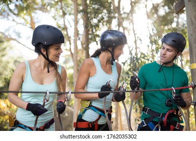 Coach assisting trainee in zip line on a sunny day - Powered by Shutterstock