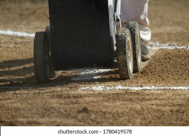 A coach chalks the outline of the batter's box before a baseball game.