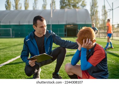 Coach comforting crying little soccer player after missed goal - Powered by Shutterstock