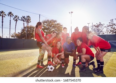 Coach With Digital Tablet Discussing Tactics With Womens Football Team Training For Soccer Match