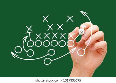 Coach Drawing American Football Or Rugby Game Playbook, Strategy And Tactics With White Marker On Green Background. 