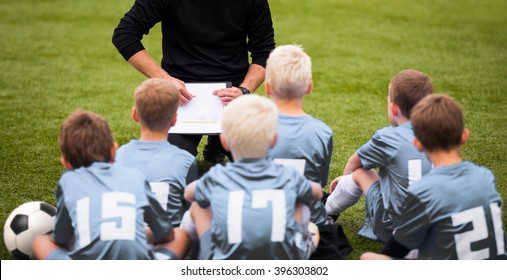 Coach Encouraging Boys Soccer Team. Soccer Football Team with Coach at the Stadium. Coach with Youth Soccer Team. Boys Listen to Coach's Instructions. Coach Giving Team Talk - Powered by Shutterstock