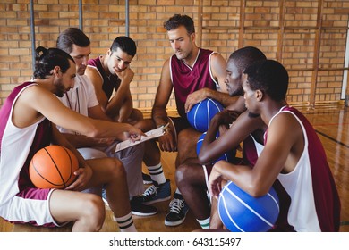 Coach explaining game plan to basketball players in the court - Powered by Shutterstock