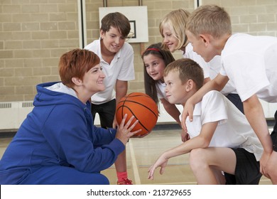 Coach Giving Team Talk To Elementary School Basketball Team