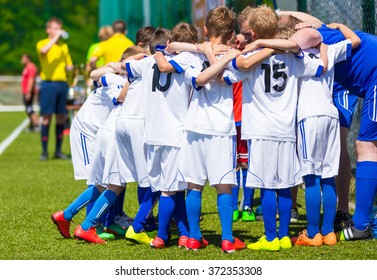 Coach Giving Young Soccer Team Instructions. Youth Soccer Team Together Before Final Game. Football Match For Children. Boys Group Shout Team, Gathering. Coach Briefing. Soccer Football Background.