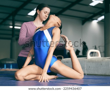 Coach, gymnastics and athlete training with trainer at the gym learning and helping with exercise. Teaching, stretches and gymnast in a workout with instructor preparing for sports competition