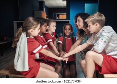 The coach and her little soccer players building up togetherness in a locker room - Powered by Shutterstock