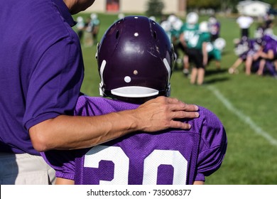 Coach With His Arm Around His Player On The Sidelines