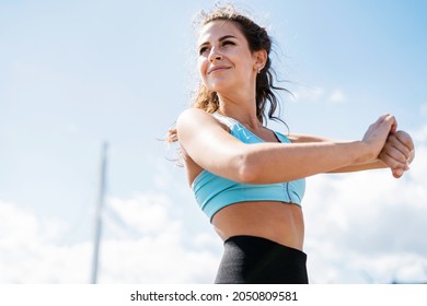 Coach, look at the smartwatch. The athlete leads a healthy lifestyle. Cardio training for weight loss. Sports and clothing for women. Fitness break in the city.