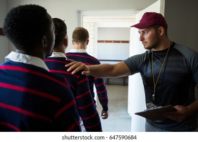 Coach motivating rugby team while standing at locker room - Powered by Shutterstock