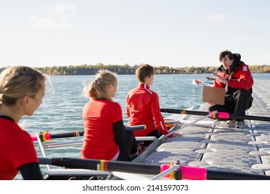 Coach talking to rowing team in scull - Powered by Shutterstock