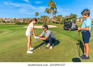 Coach teaching a girl and her brother to play golf in summer in a luxury course - Powered by Shutterstock