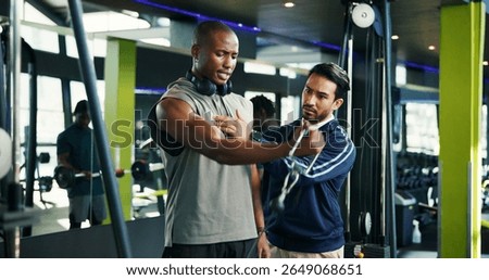 Coach, teaching and man with cable machine, exercise and support in bodybuilding. Personal trainer, advice or athlete in training with gym equipment for muscle, power and workout for fitness tips