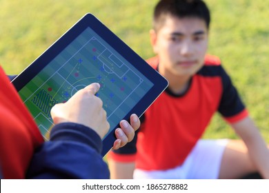 Coach training a tactic for asian teenager football player. - Powered by Shutterstock