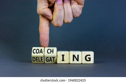Coaching or delegating leadership style symbol. Businessman turns cubes and changes words 'delegating' to 'coaching'. Beautiful grey background, copy space. Business, coaching or delegating concept.
