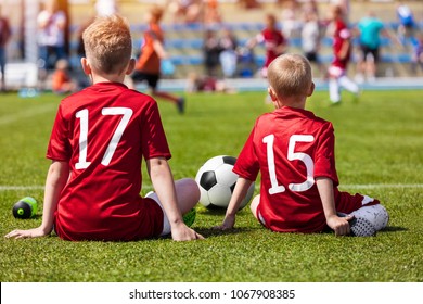 Coaching Kids Soccer. Young Boys Sitting On Football Field And Watching Tournament Game. Football Match For Children