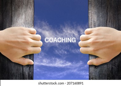 "coaching" text in the sky behind 2 hands opening the wooden door.