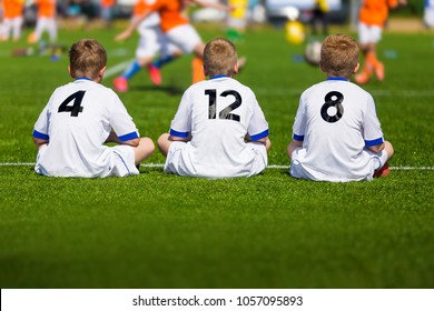 Coaching Youth Soccer. Young Boys Sitting On Football Field And Watching Tournament Game. Football Match For Kids