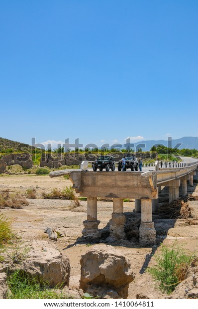 Coahuila, Mexico.\
August 7, 2010.\
All terrain vehicles stopped in a highway bridge\
destroyed by Hurricane\
Alex.