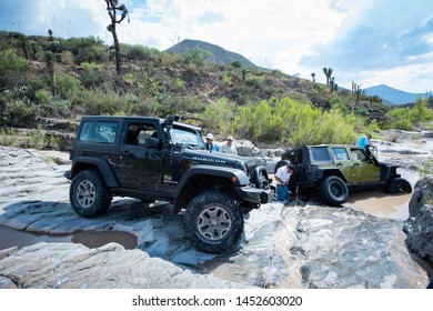 Coahuila, Mexico. July 13, 2019. 4x4 Jeep  Gets Stuck  In A Difficult Muddy Rock Road.  Men Use A Winch To Take It Out.