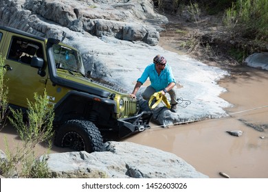 Coahuila, Mexico. July 13, 2019. 4x4 Jeep  Gets Stuck  In A Difficult Muddy Rock Road.  Men Use A Winch To Take It Out.