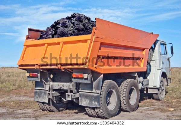 Coal in the back of the orange truck. Coal\
mining. Coal delivery