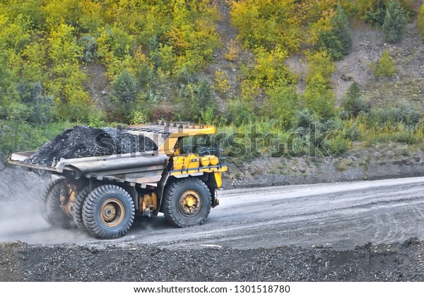 Coal in the back of the yellow truck. Coal\
mining. Coal delivery.