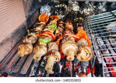 Coal Fire Bbq Grill With Tasty Barbecue Chicken, Aluminium Foil Baking Potatoes And Vegetables Cooking In Marbella, Spain                                