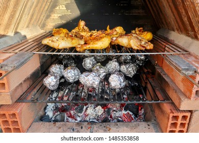 Coal Fire Bbq Grill With Tasty Barbecue Chicken, Aluminium Foil Baking Potatoes And Vegetables Cooking In Marbella, Spain                                