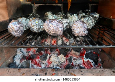 Coal Fire Bbq Grill With Tasty Barbecue Chicken, Aluminium Foil Baking Potatoes And Vegetables Cooking In Marbella, Spain                                