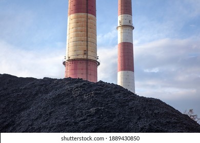 Coal heap, natural black coal with industrial chimney. Industrial landscape with pile of carbon material. Global warming, CO2 emission, coal energy issues. Coal mine in Katowice, Poland.