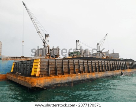 Coal loading and unloading activities at sea from barges to large ships.