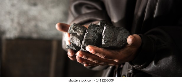 Coal mining : coal miner in the man hands of coal background. Picture idea about coal mining or energy source, environment protection. Industrial coals. Volcanic rock. Panorama photo - Shutterstock ID 1411256009