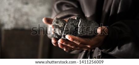 Coal mining : coal miner in the man hands of coal background. Picture idea about coal mining or energy source, environment protection. Industrial coals. Volcanic rock. Panorama photo